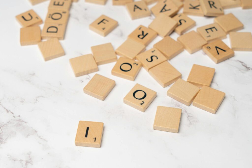 Scrabble tiles on a white surface with the letters written on them